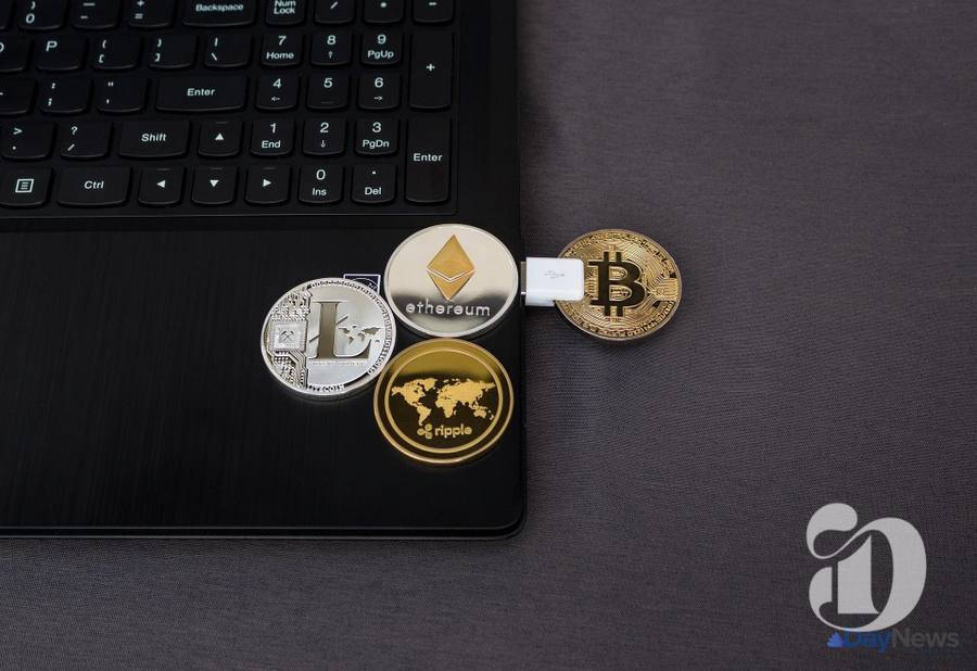 Monede virtuale Bitcoin, Ethereum, Litecoin și Ripple pe un laptop negru