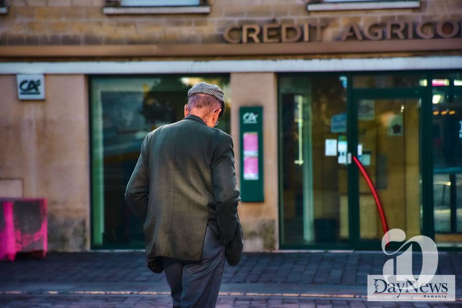 Batran cu mana in buzunar trece strada