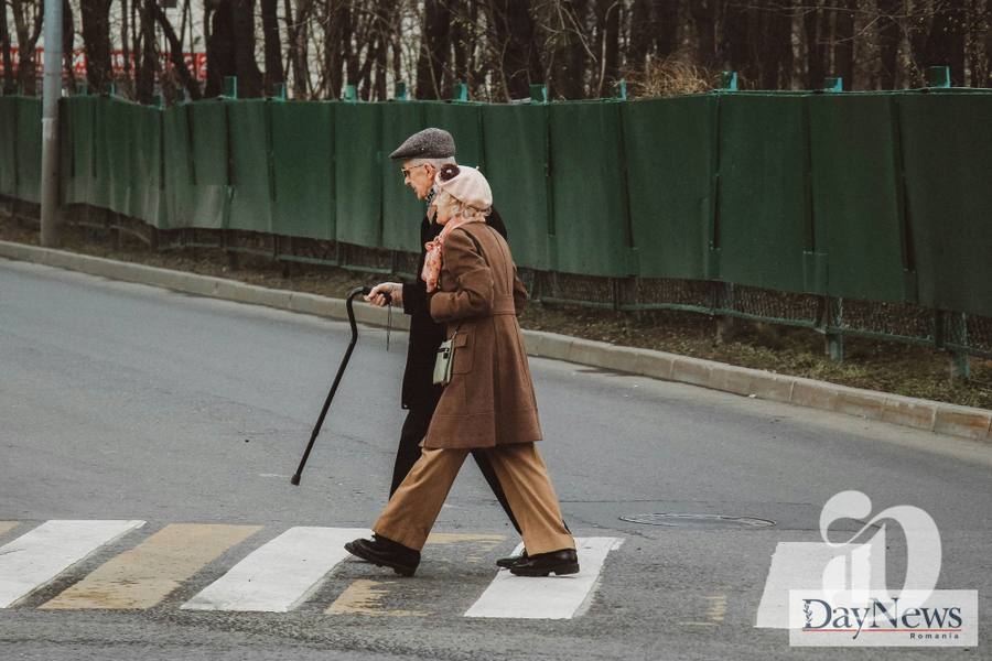 Cuplu de batrani traverseaza pe trecerea de pietoni