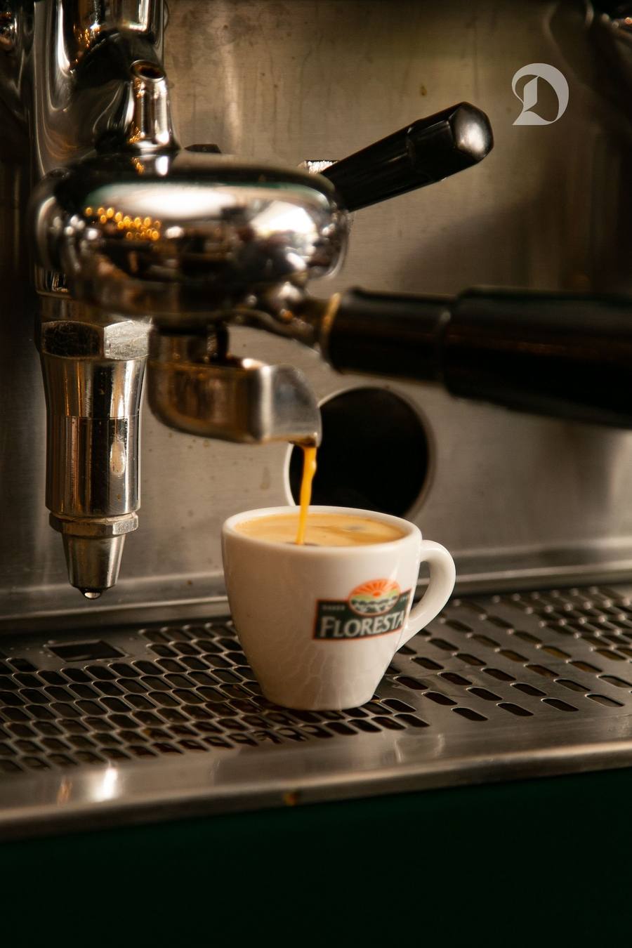 Prim-plan cu espresso turnându-se dintr-o mașină într-o ceașcă într-un cafe-restaurant Santos.